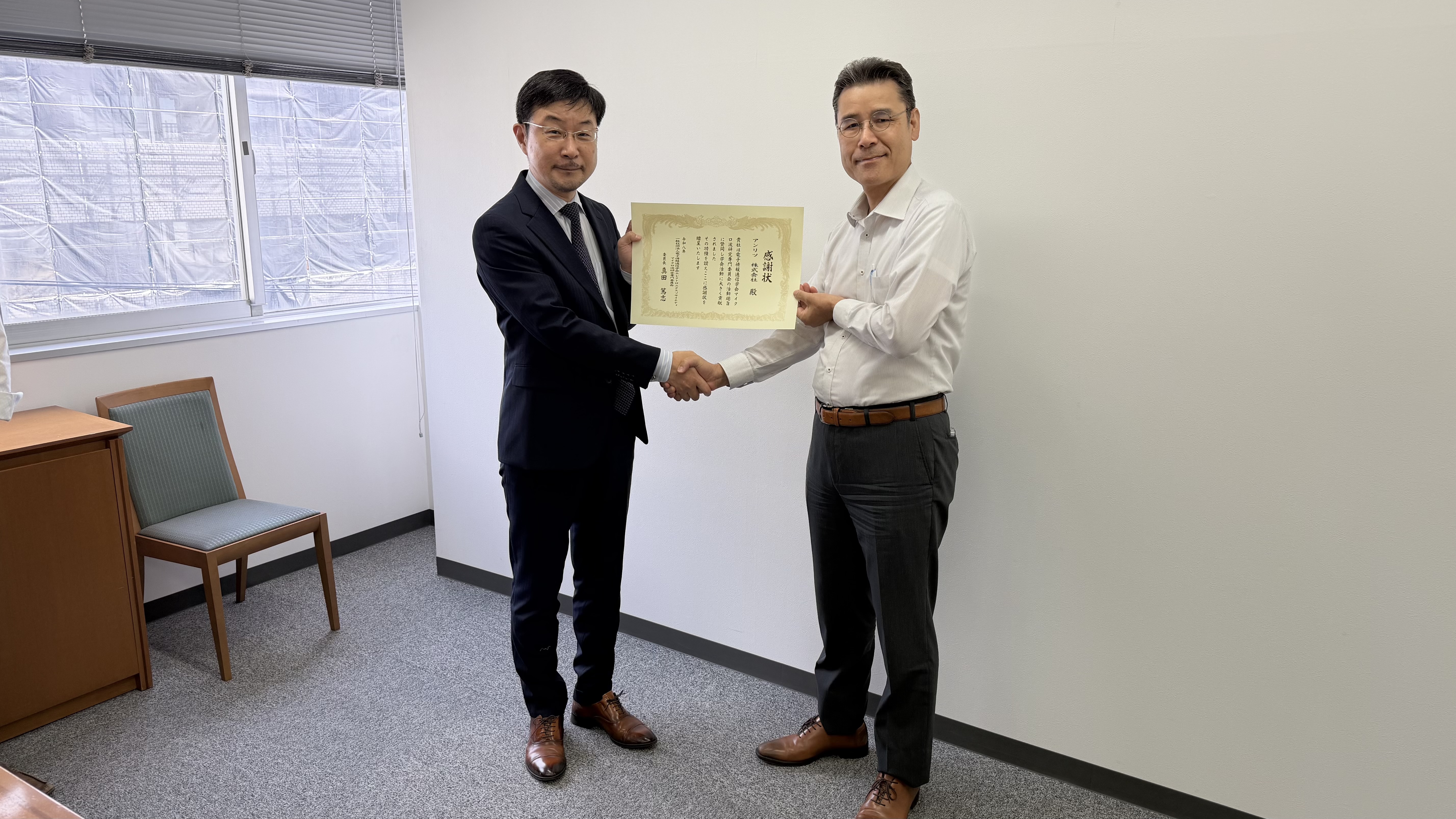 アンリツ株式会社様への感謝状贈呈、二人で感謝状を持つ様子