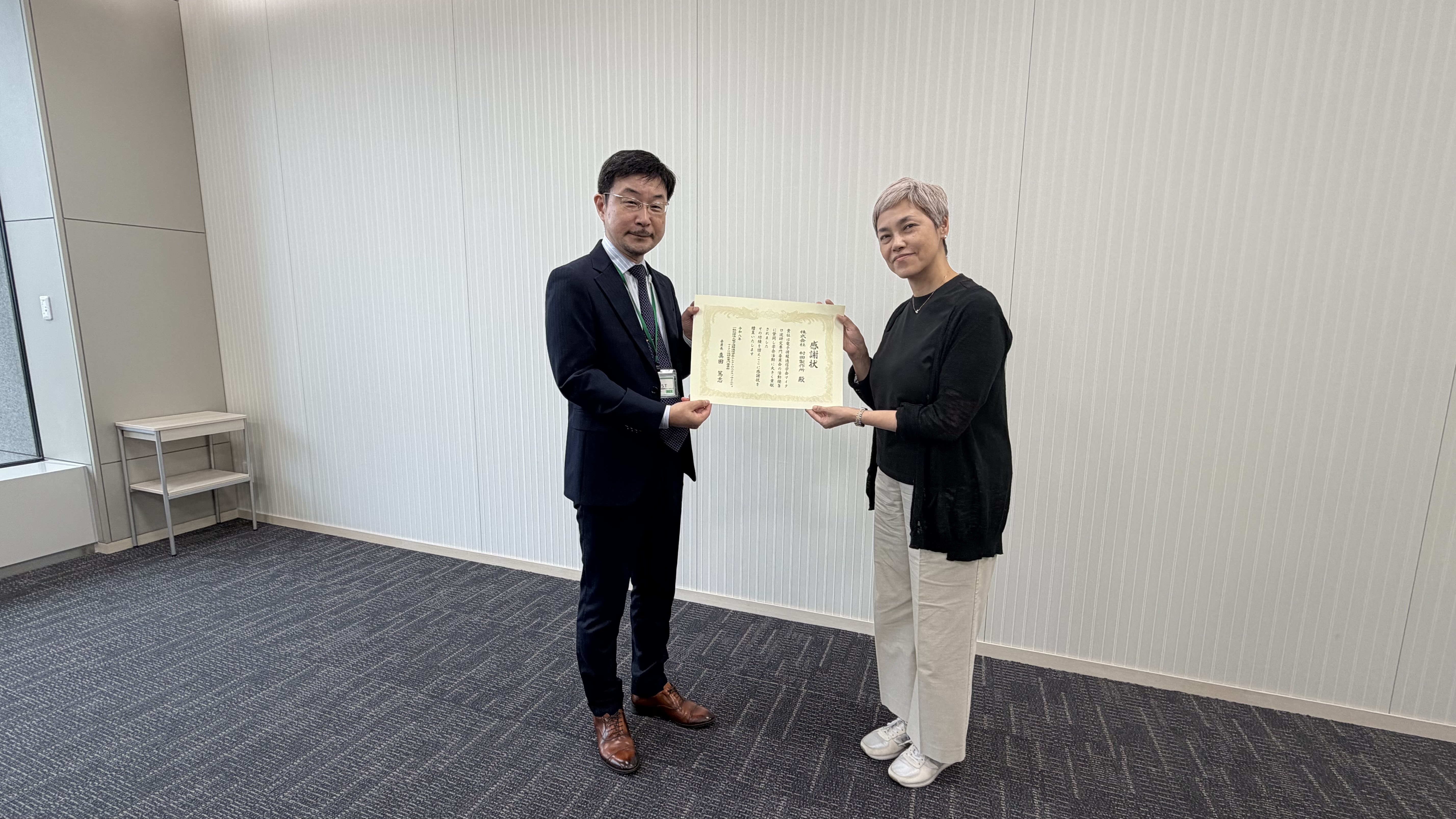 株式会社村田製作所様への感謝状贈呈、二人で感謝状を持つ様子